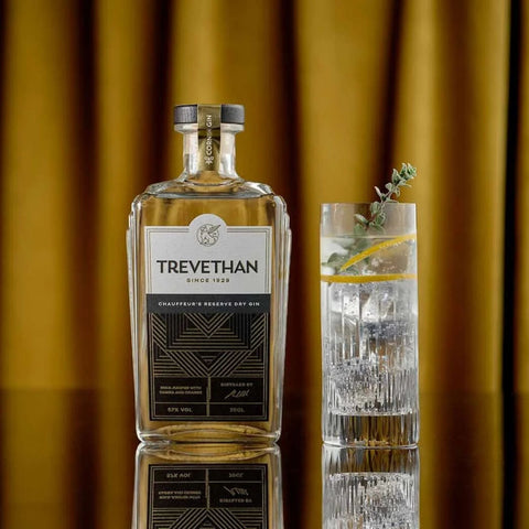 Bottle and glass of Gin Infront of yellow curtains