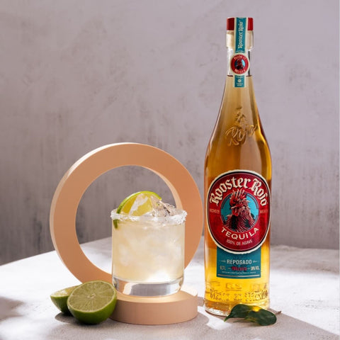 Tequila bottle and glass next to lime